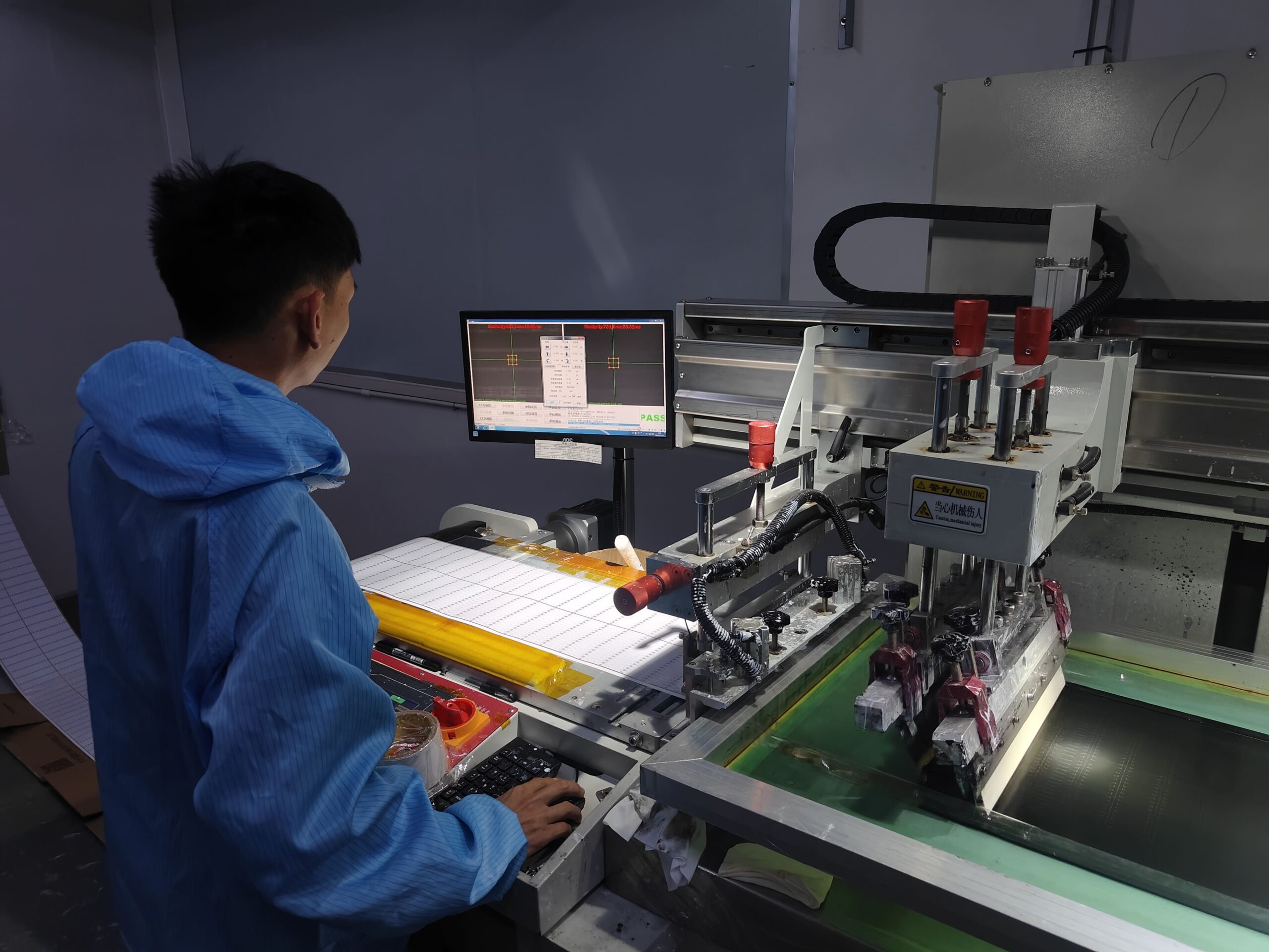 Factory technician adjusting the printing program settings on the solder paste printer machine for LED strip PCB production.